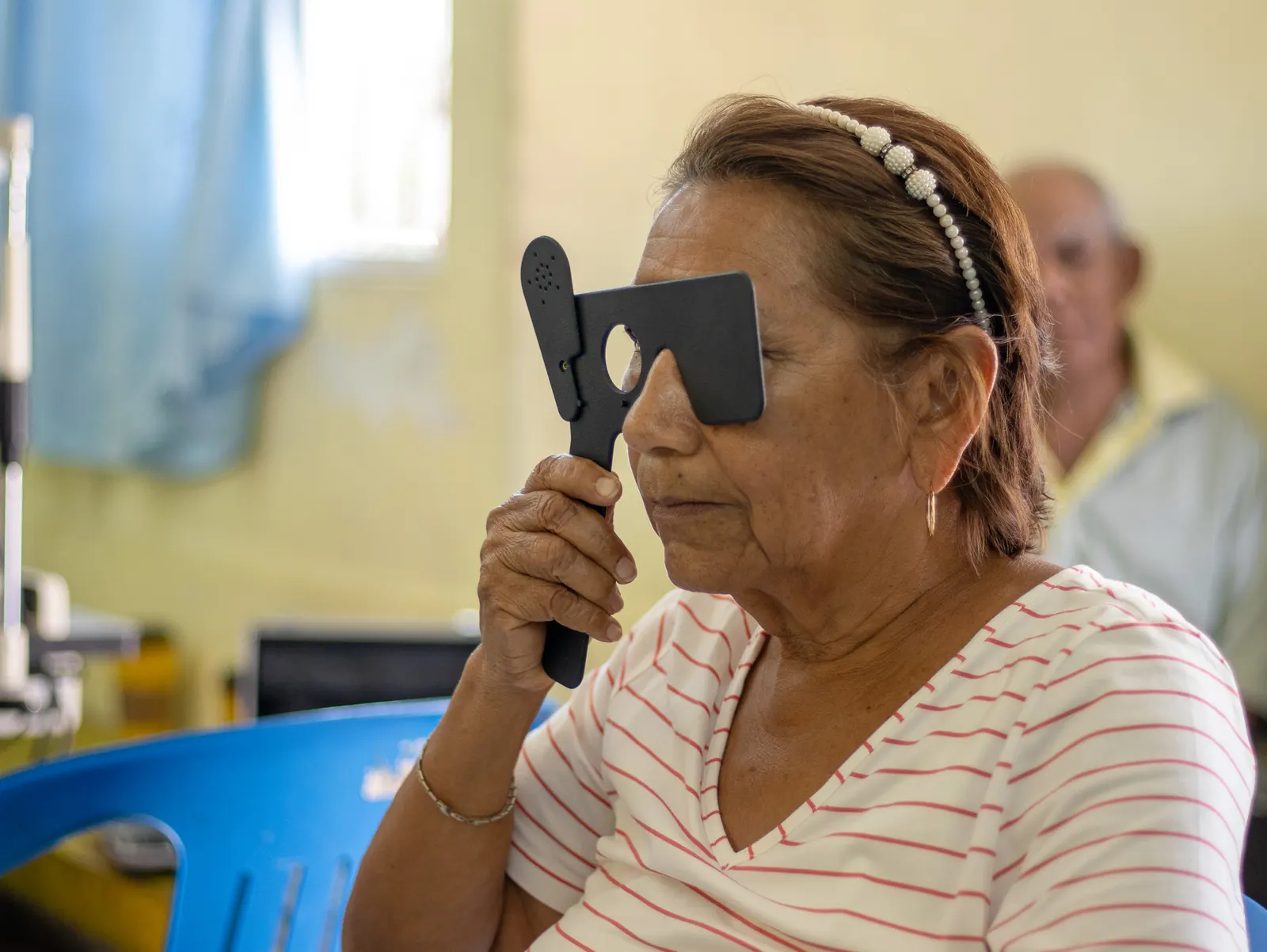 Paciente se cubre un ojo con un oclusor durante la prueba de visión