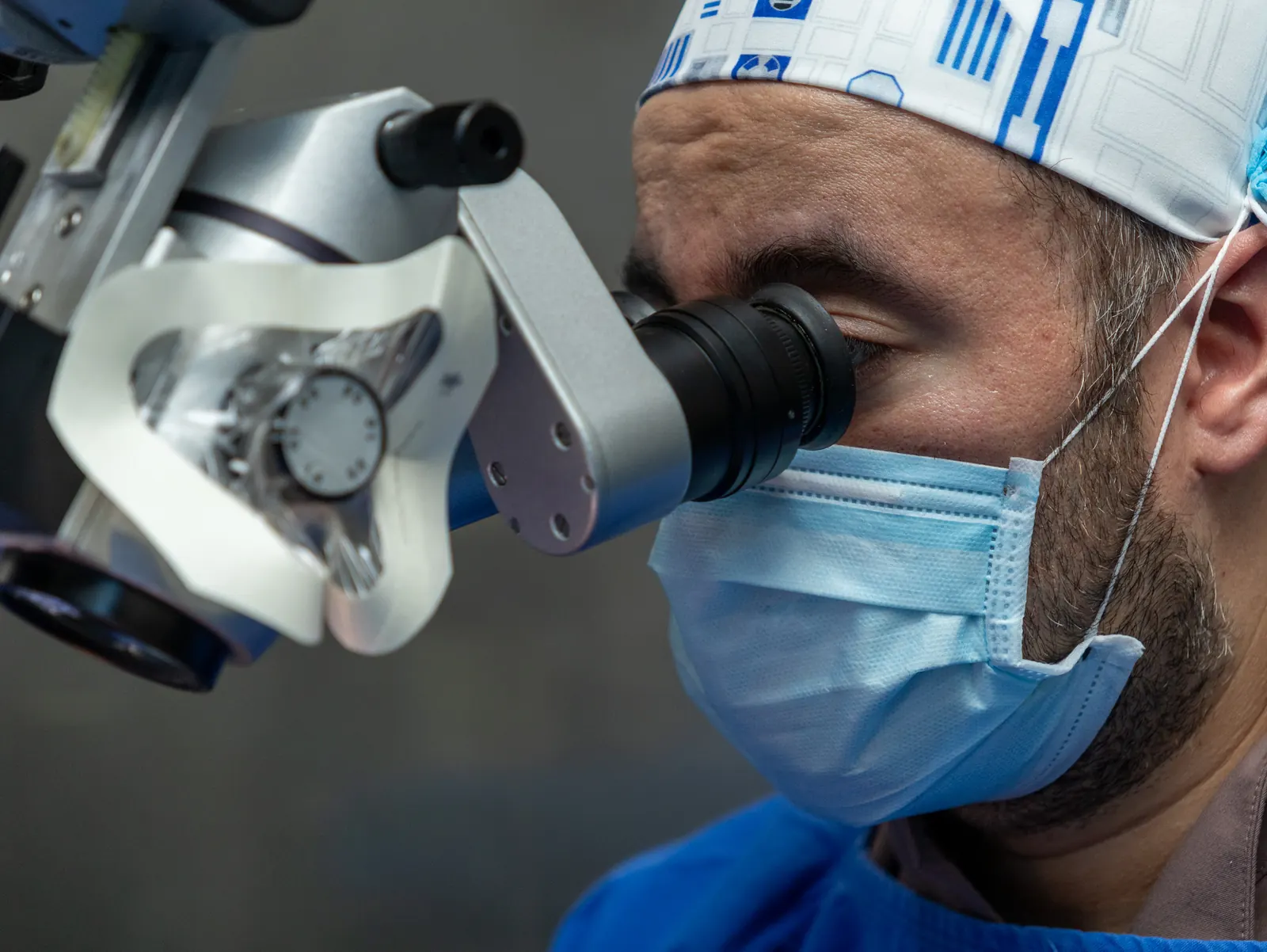 Cirujano mira por el microscopio quirúrgico durante una operación en la unidad móvil